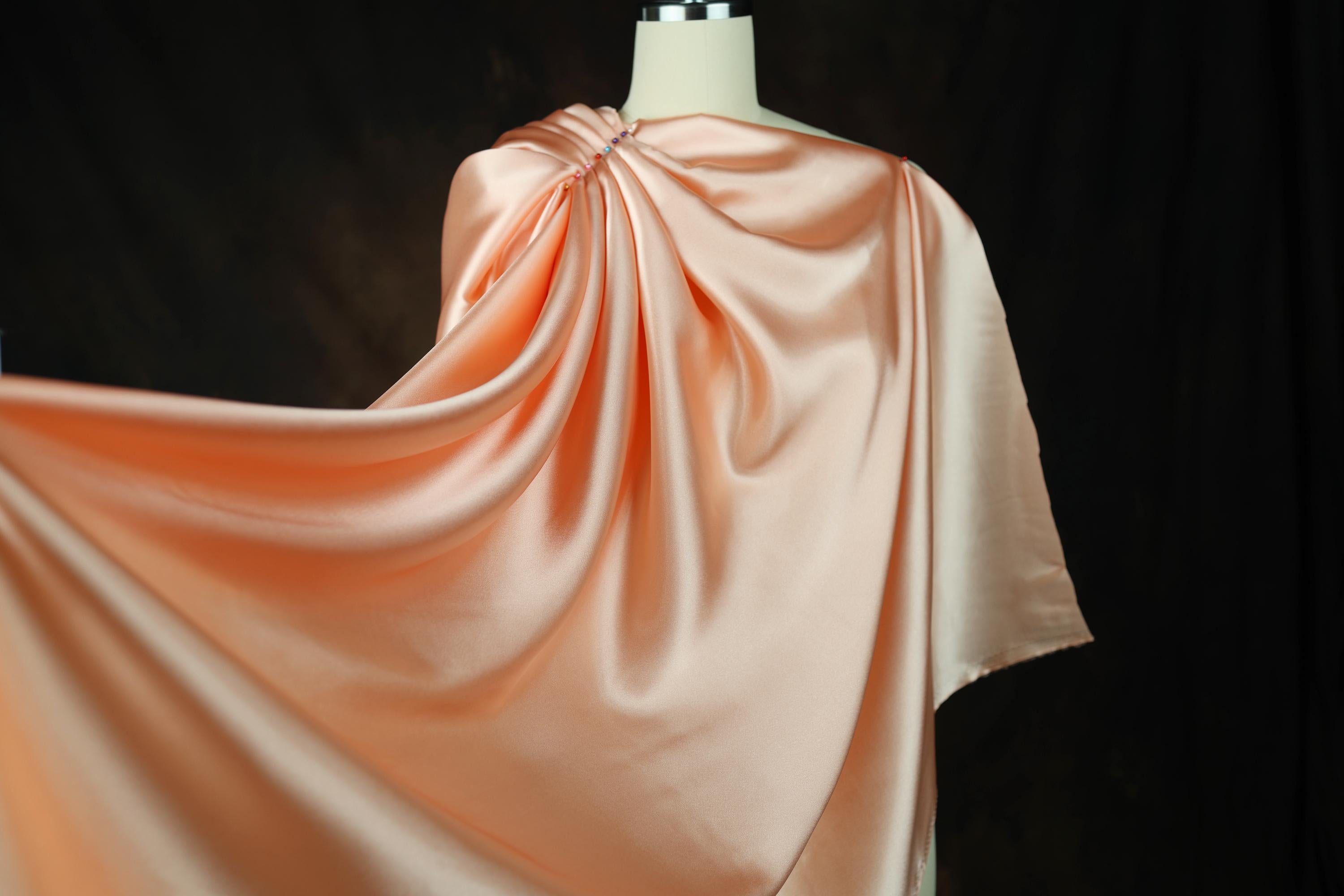 a dress on a mannequin wearing a pink cape
