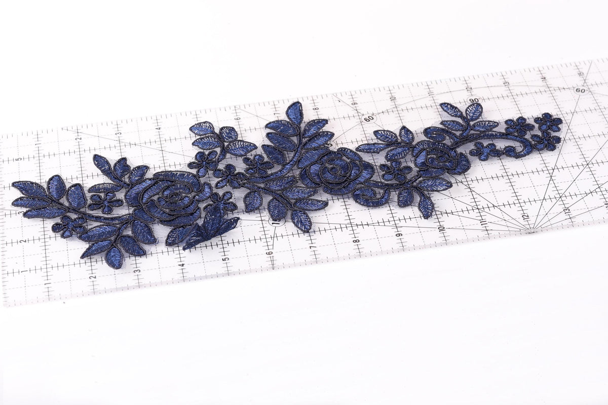 a clear ruler with blue floral embroidery designs on it.