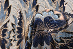 a close-up view of a fabric with a floral pattern, showcasing intricate details and a rich, blue-toned color scheme.