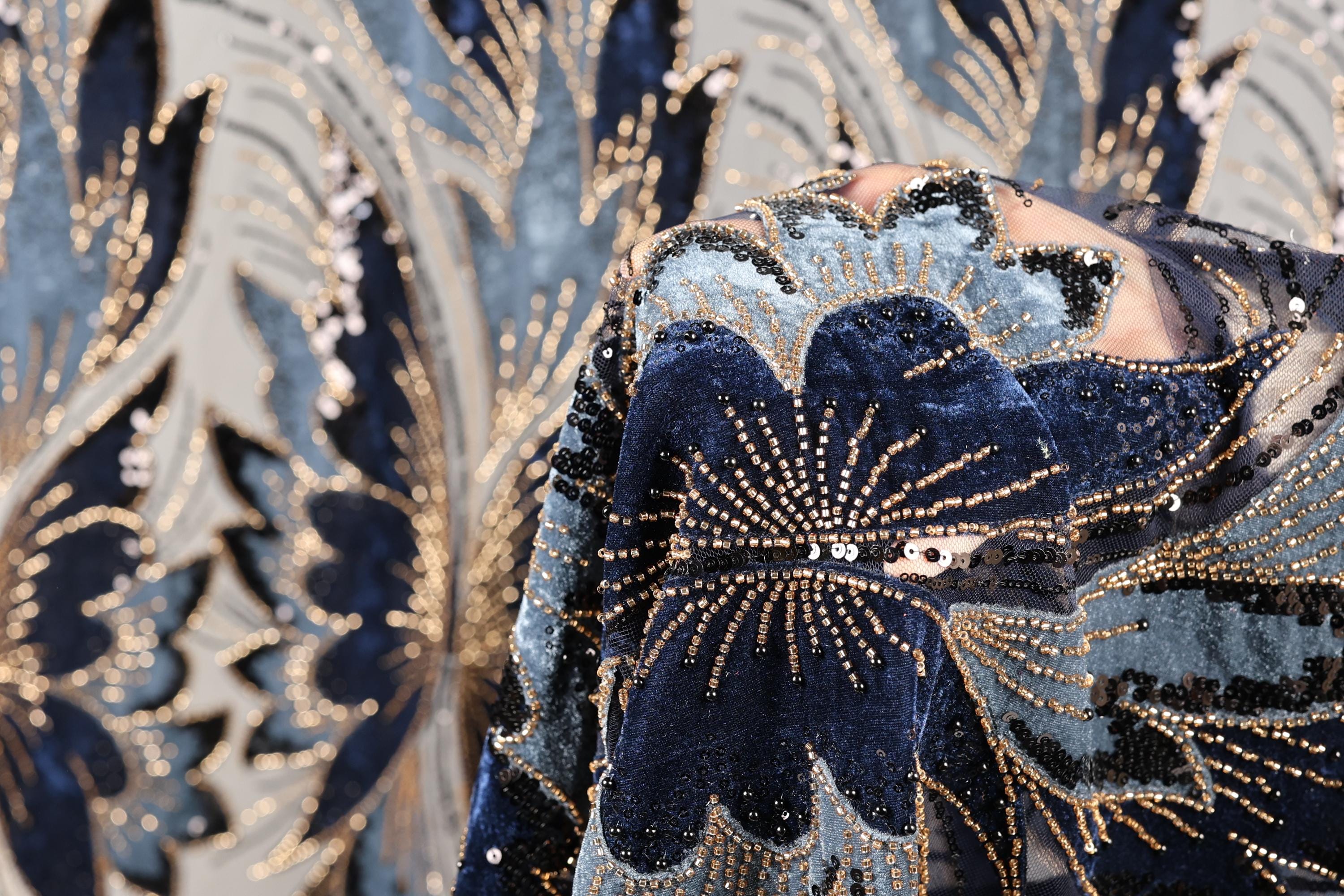 a close-up view of a fabric with a floral pattern, showcasing intricate details and a rich, blue-toned color scheme.