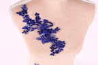 a mannequin torso with a decorative blue sequin floral piece attached to it.