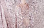 a mannequin wearing a dress with a delicate, intricate floral pattern. The dress is predominantly pink and white, with the floral design being the most prominent element. The mannequin is positioned in the center of the image, showcasing the dress and its details.