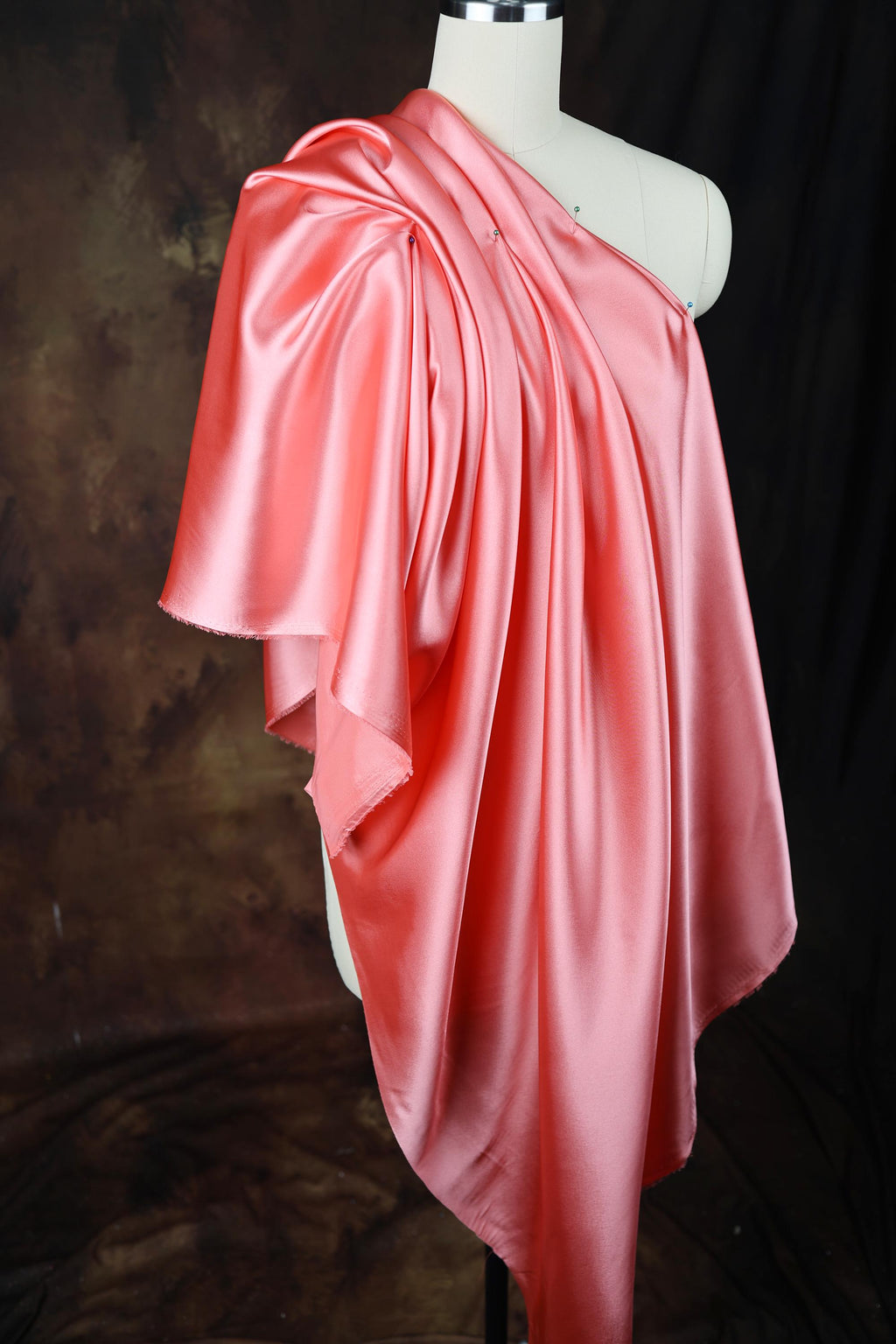 a mannequin wearing a pink dress on a black background