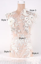 A mannequin with a white lace bodice adorned with various floral and leaf-like embellishments, each labeled with a different style number.