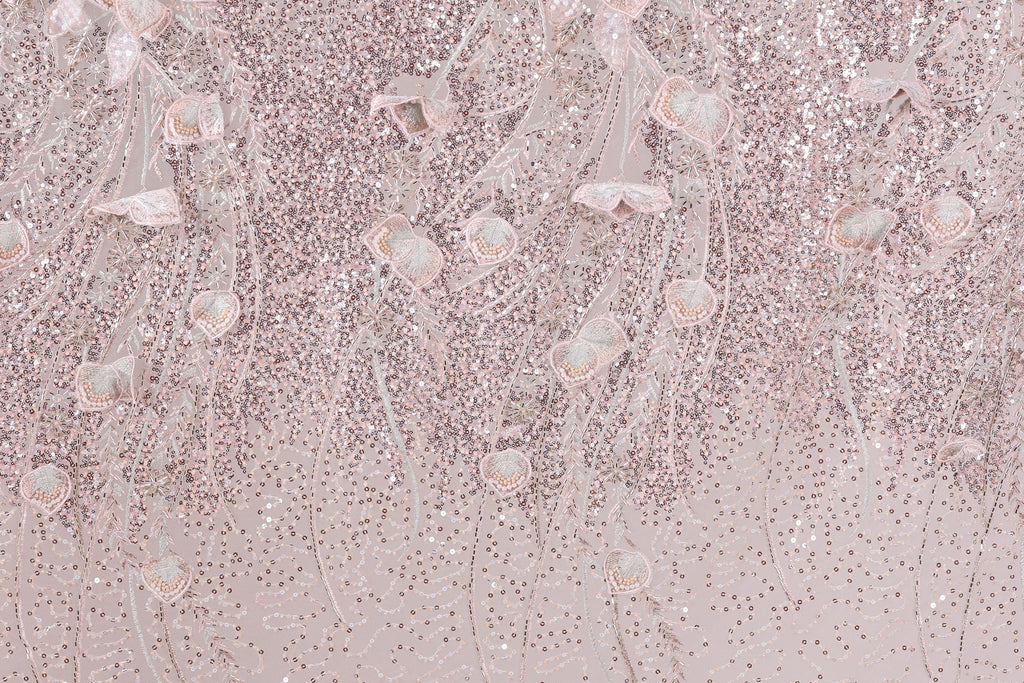 a background with a pink and white color scheme, adorned with a pattern of sequins and delicate flowers. The pattern appears to be a decorative textile or fabric, with the pink and white colors creating a visually appealing and harmonious design.