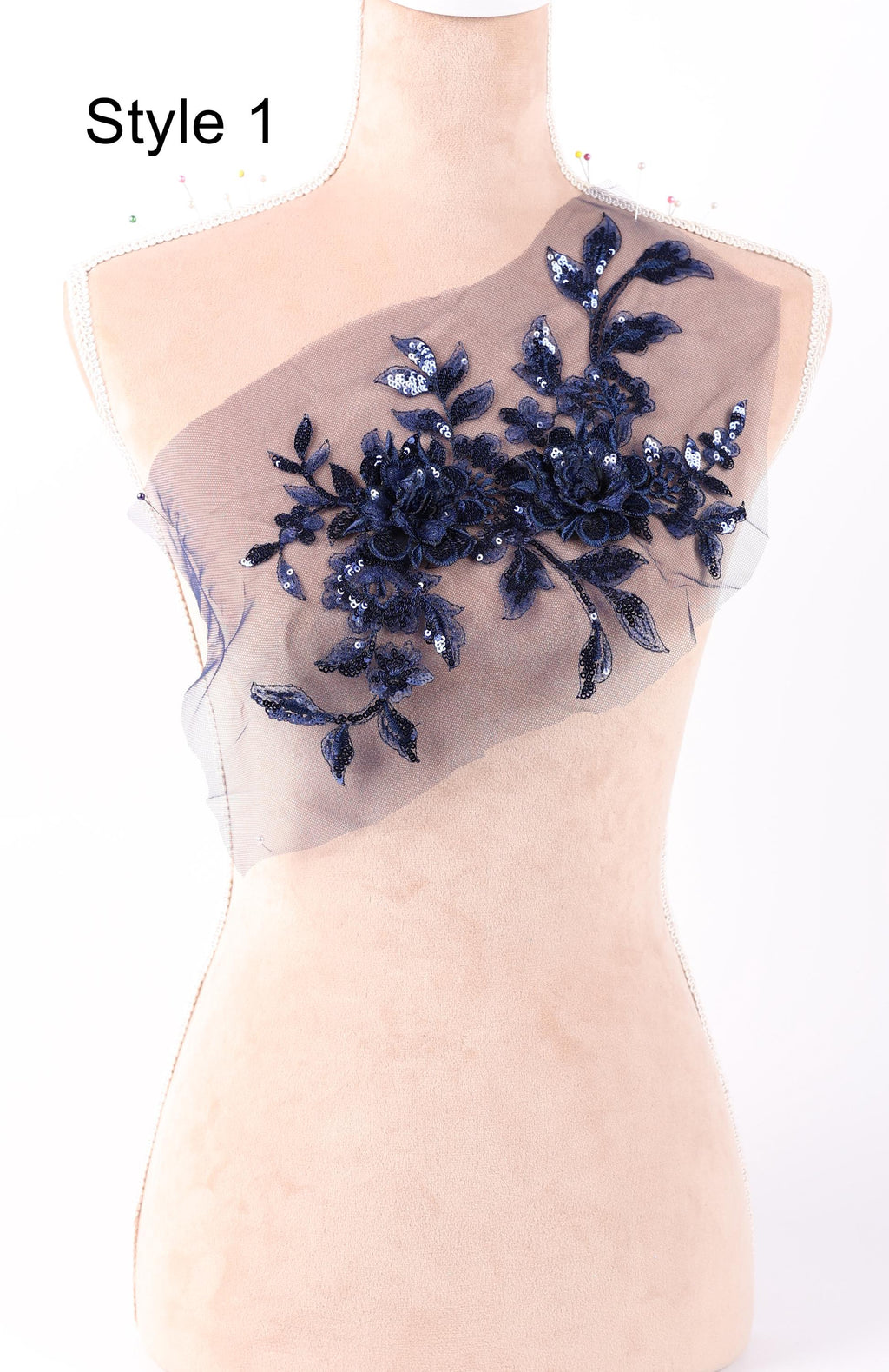 A mannequin with a decorative fabric piece featuring a floral pattern in navy blue and white colors.