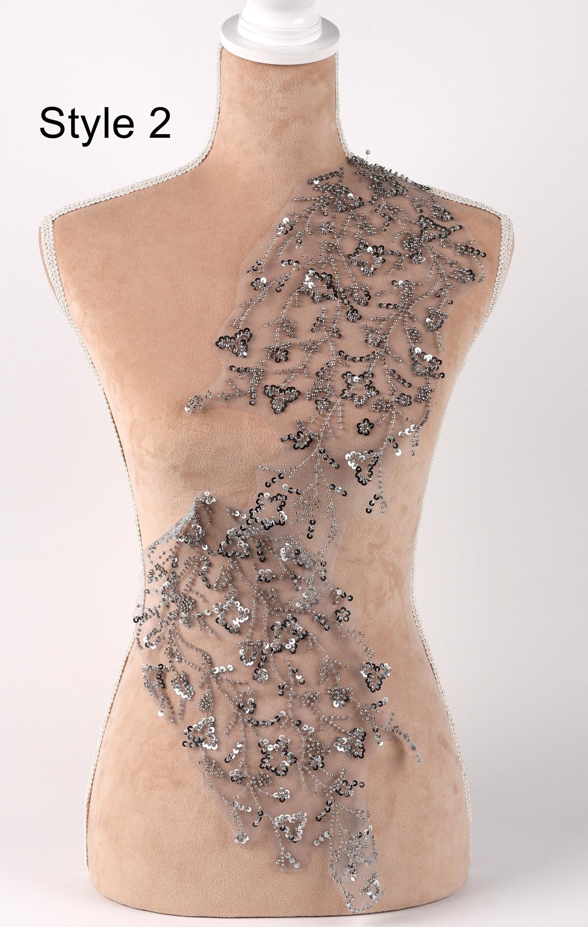 A mannequin with a beige body and a decorative silver sequin overlay on its torso.