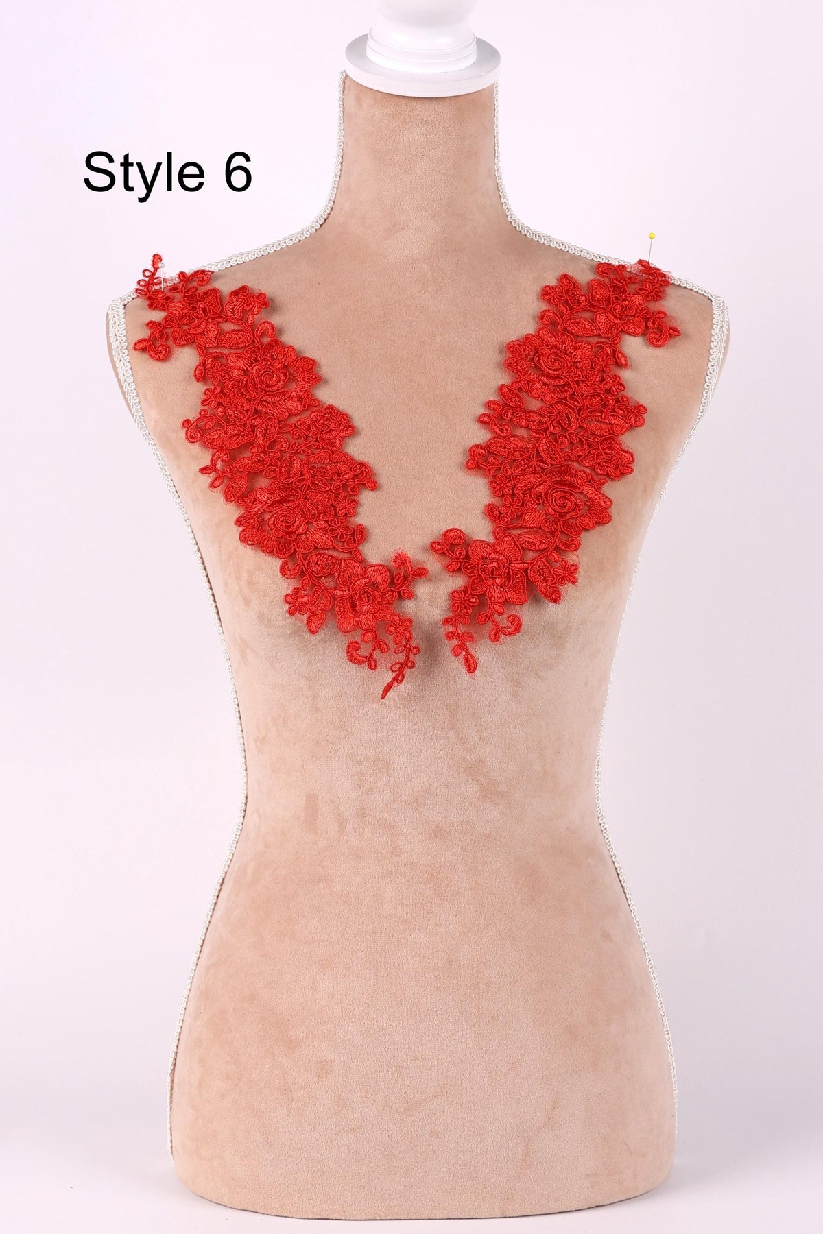 A mannequin wearing a red floral lace collar against a white background.