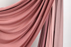 a close-up view of a fabric with a soft, flowing texture in shades of pink and red.