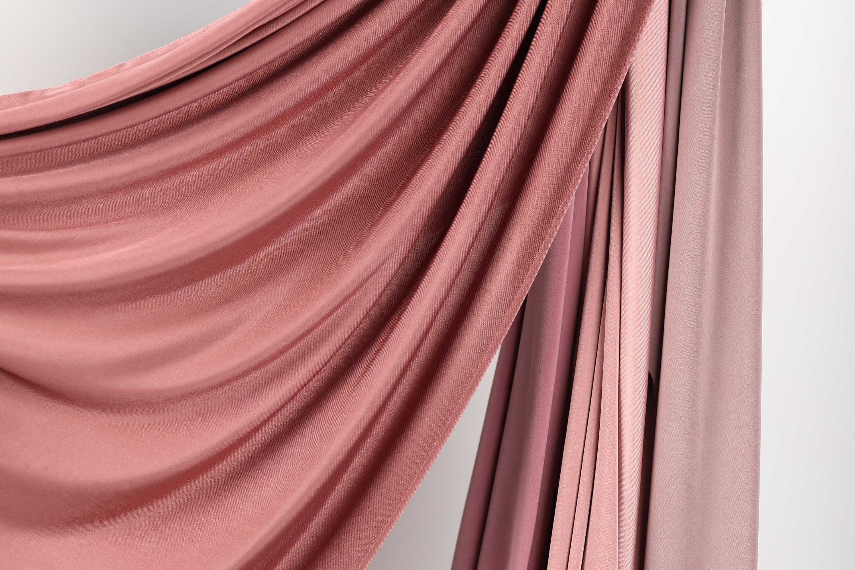 a close-up view of a fabric with a soft, flowing texture in shades of pink and red.