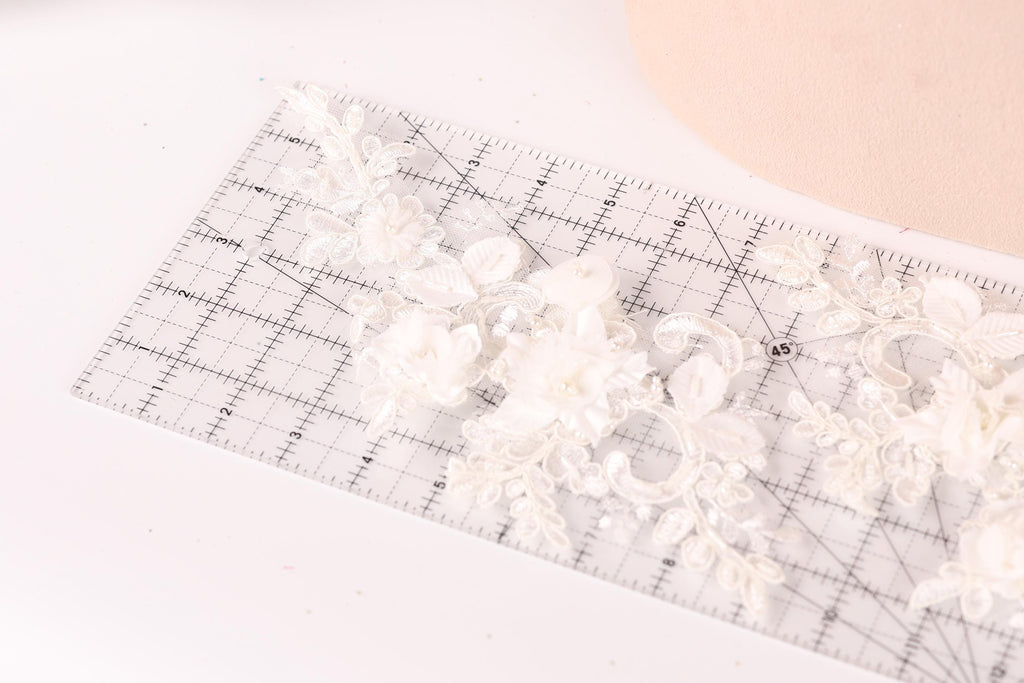 A ruler with a floral pattern on it, placed on a white surface.