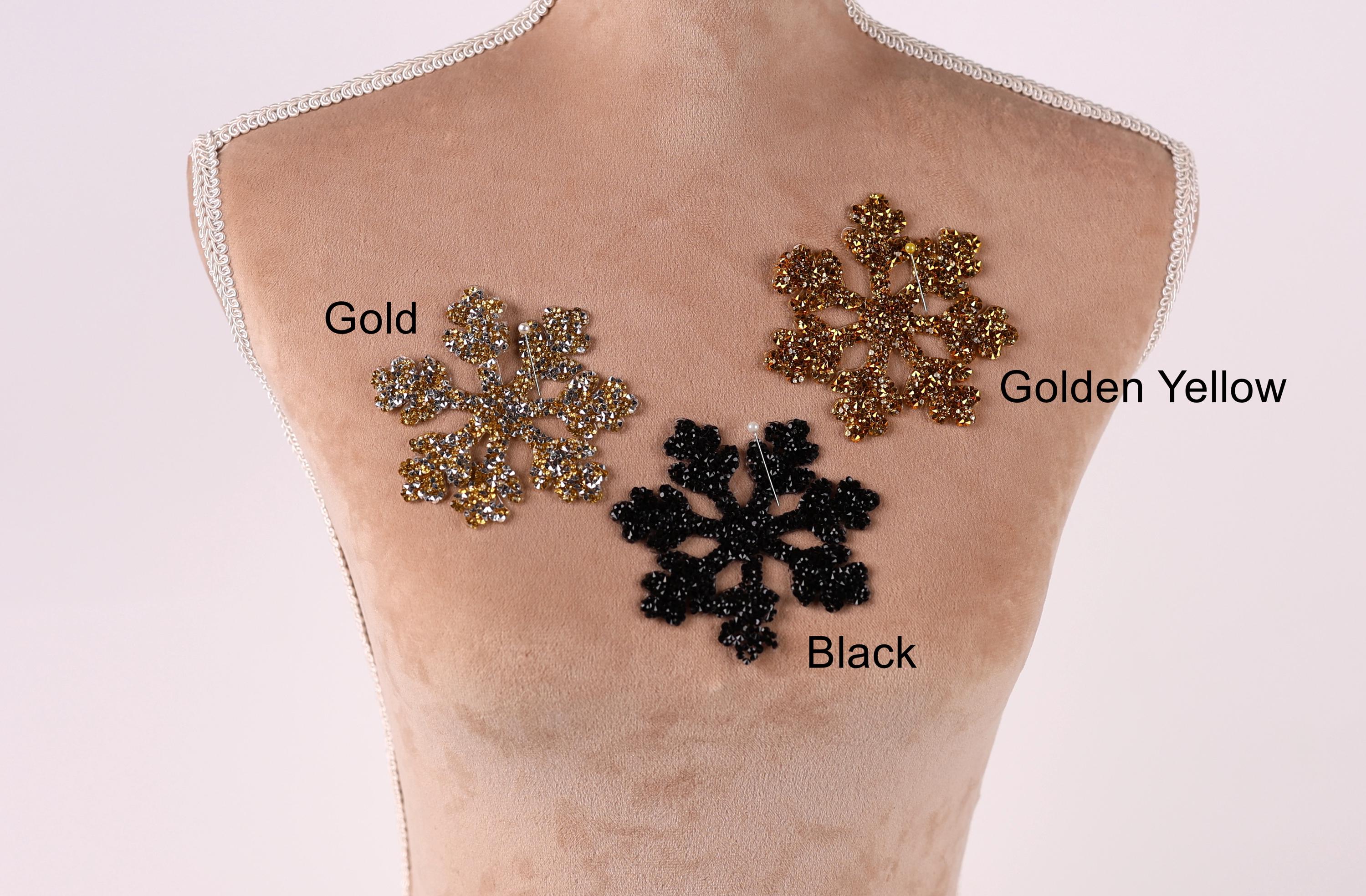 A mannequin torso with three different colored snowflake-shaped embellishments on it, labeled as gold, golden yellow, and black.