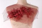 a mannequin with a red floral design on its shoulder.