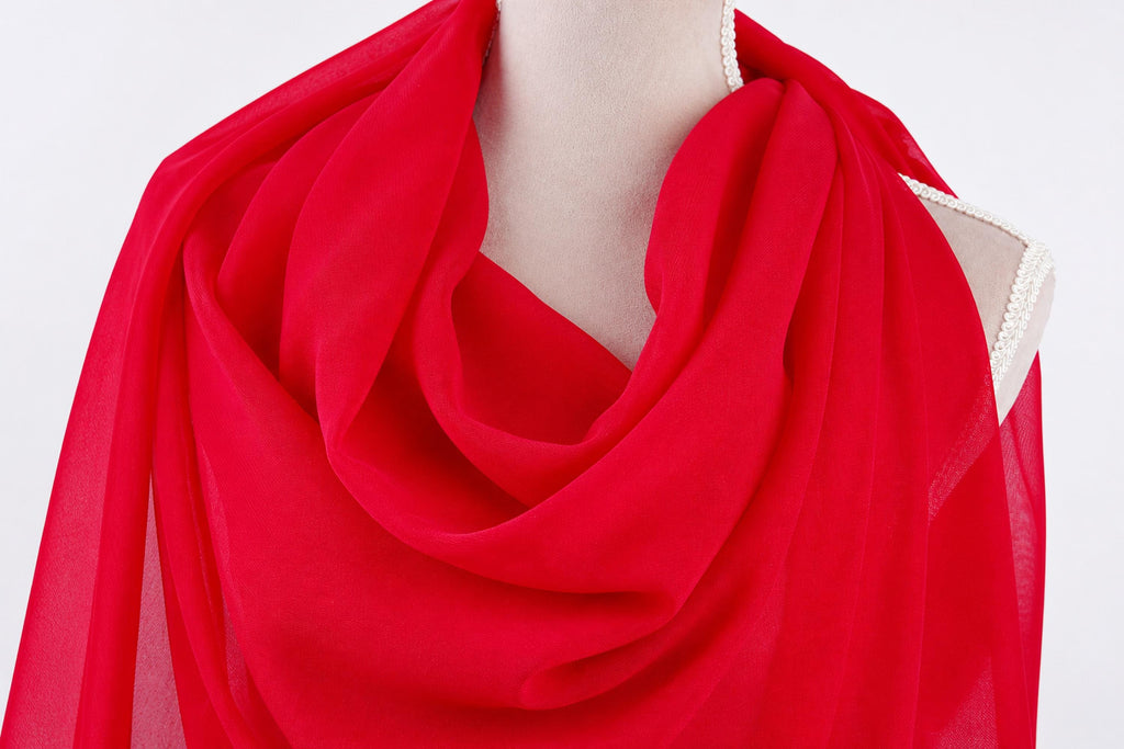 A mannequin wearing a red, flowing scarf.