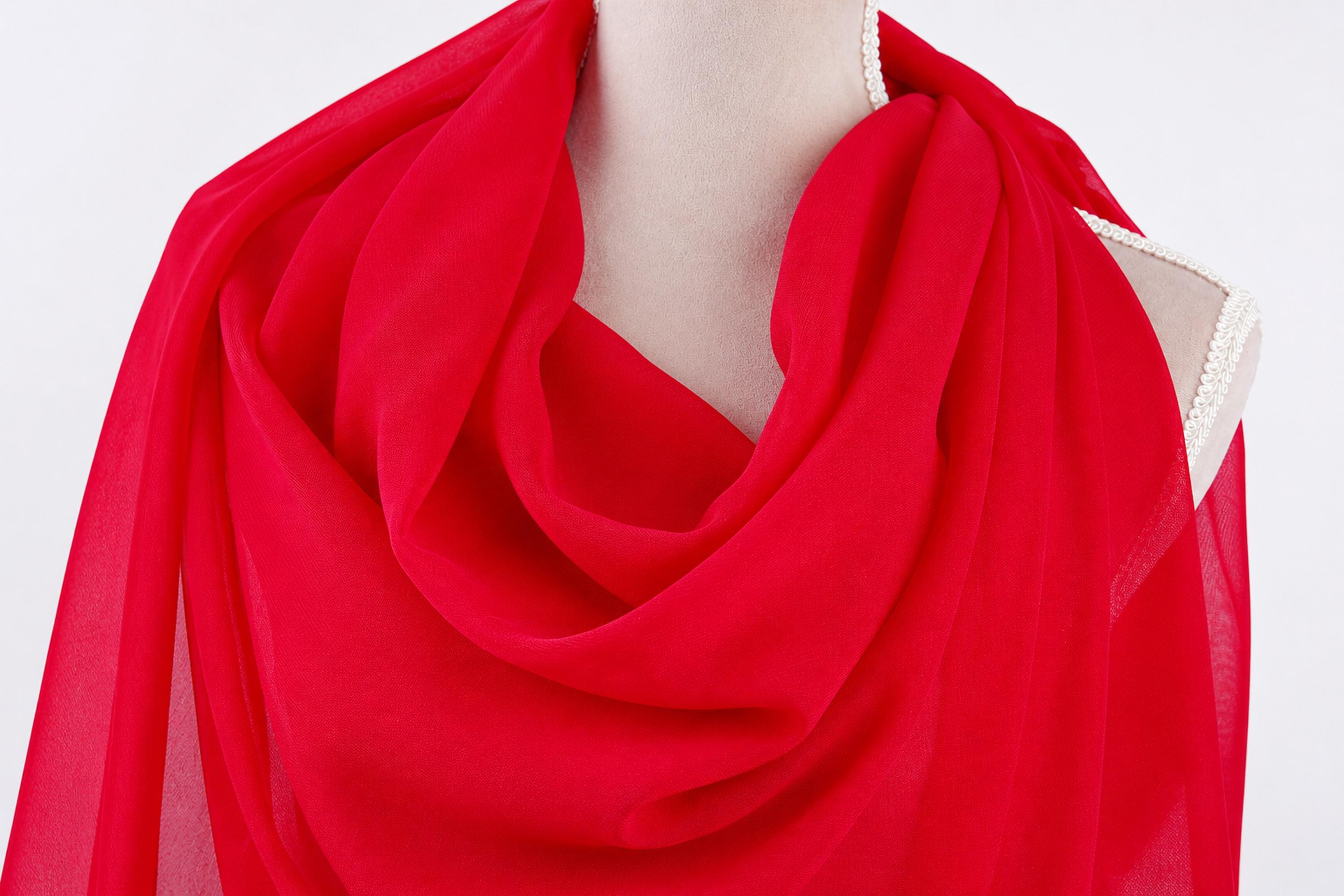 A mannequin wearing a red, flowing scarf.