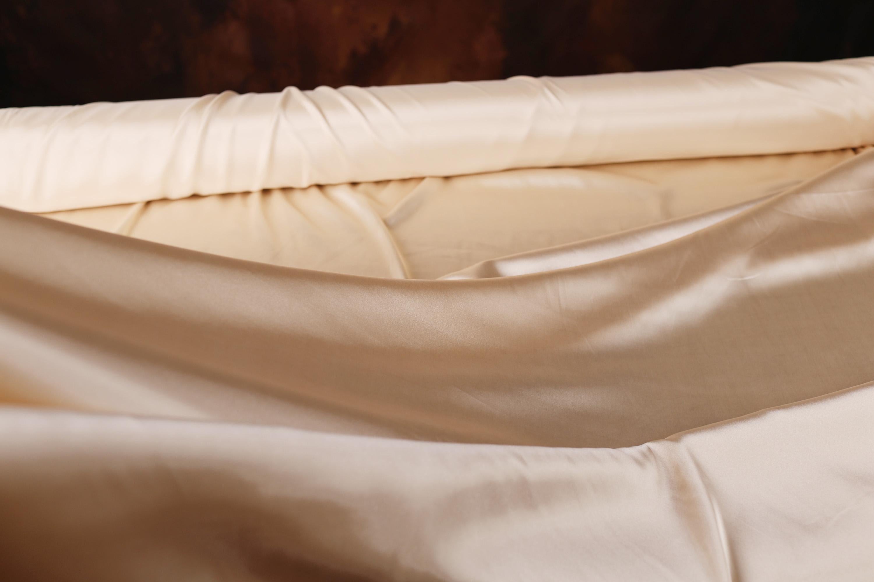 a close up of a bed with a sheet on it