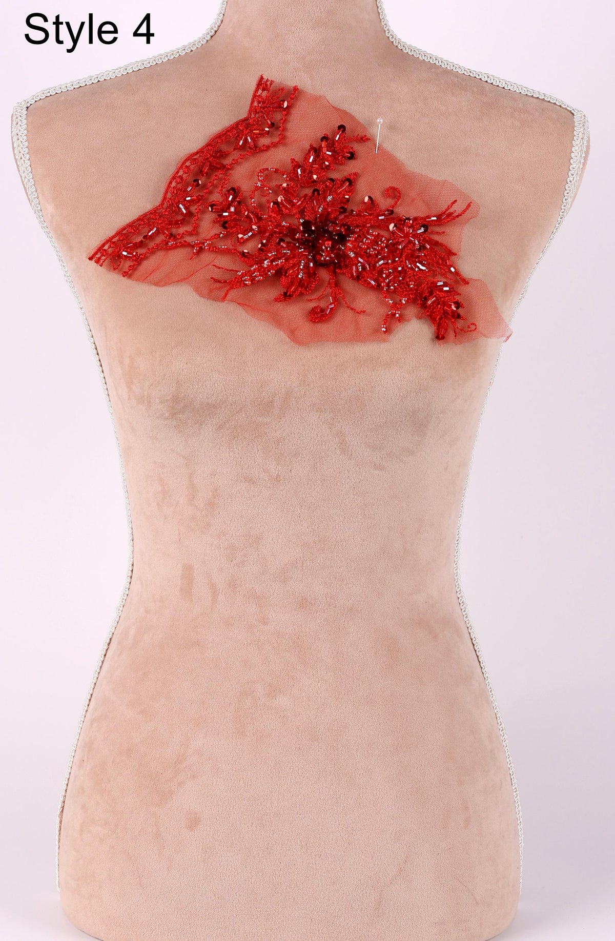A mannequin with a red floral embellishment on its back.