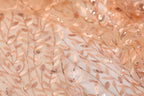 a close-up view of a fabric with a delicate, intricate pattern of leaves and branches, creating a soft, natural-looking texture.
