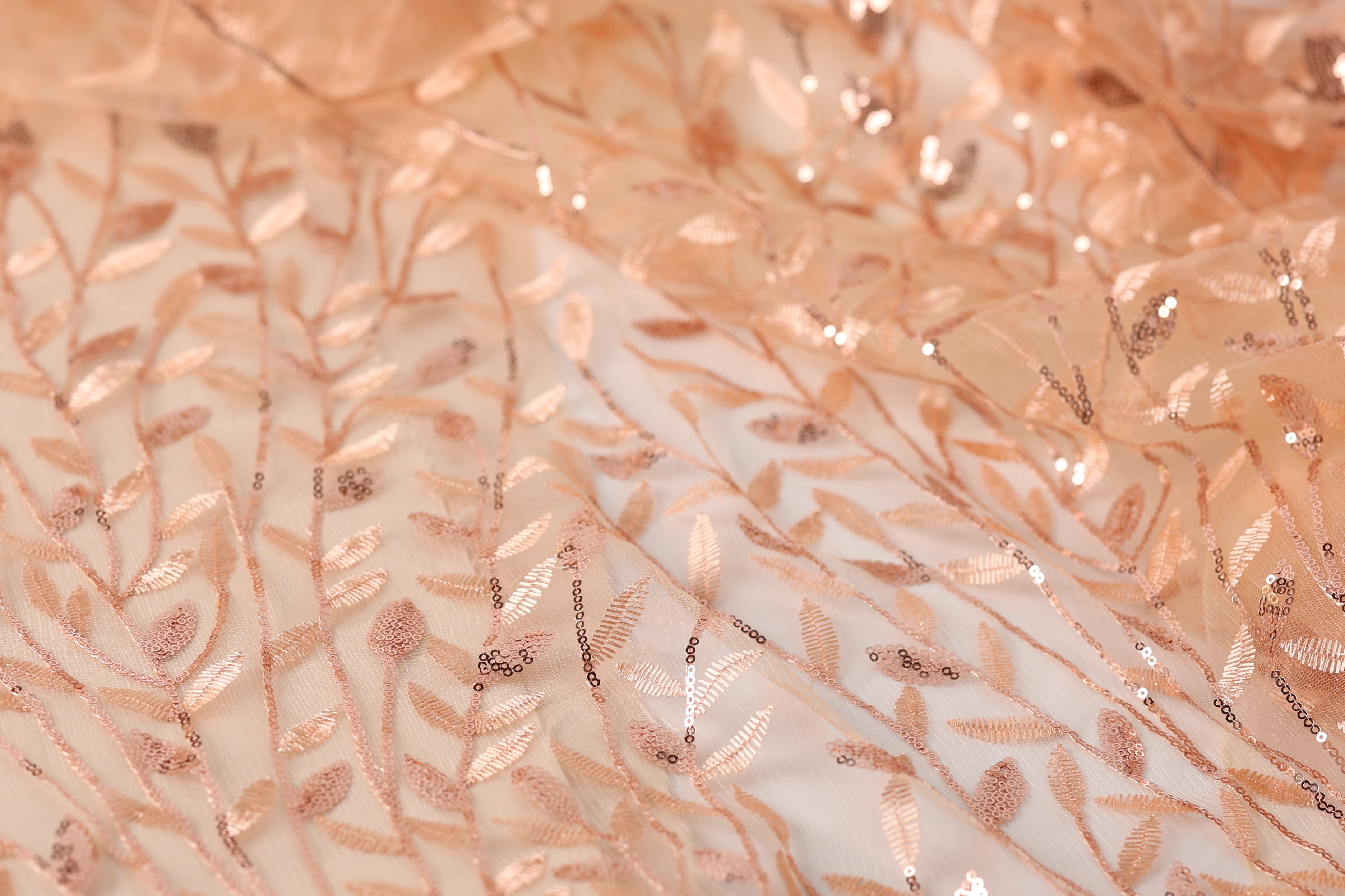 a close-up view of a fabric with a delicate, intricate pattern of leaves and branches, creating a soft, natural-looking texture.
