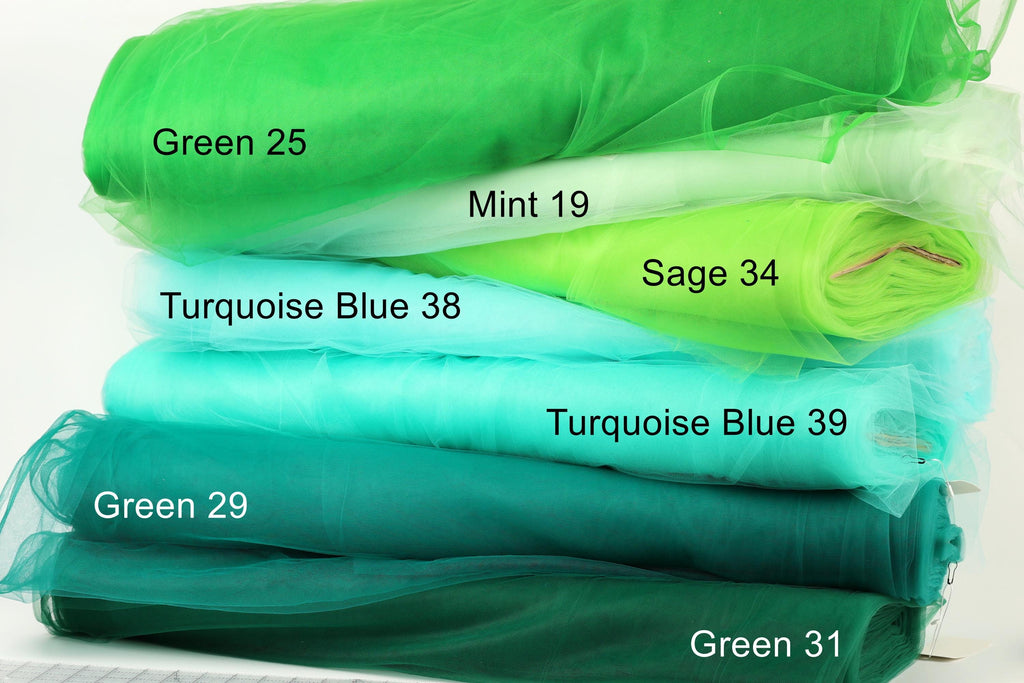 A stack of various green fabric swatches, each labeled with a different shade of green.