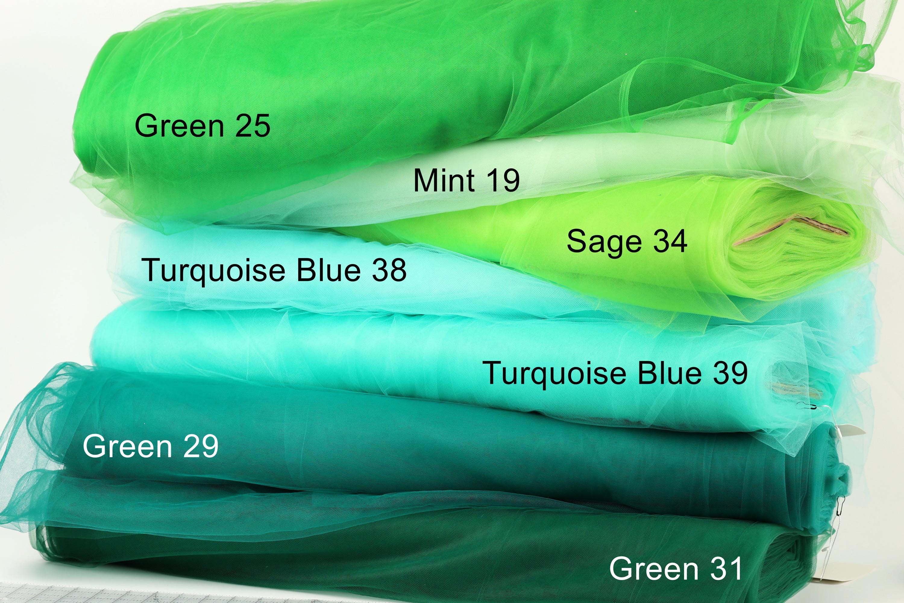 A stack of various green fabric swatches, each labeled with a different shade of green.