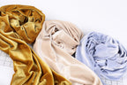 three different colored fabrics, including gold, beige, and blue, arranged on a white background.