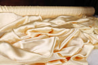 a close-up view of a pile of crumpled, light yellow satin fabric.
