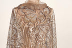 a close-up view of a gold and beige sequined dress with a floral pattern.