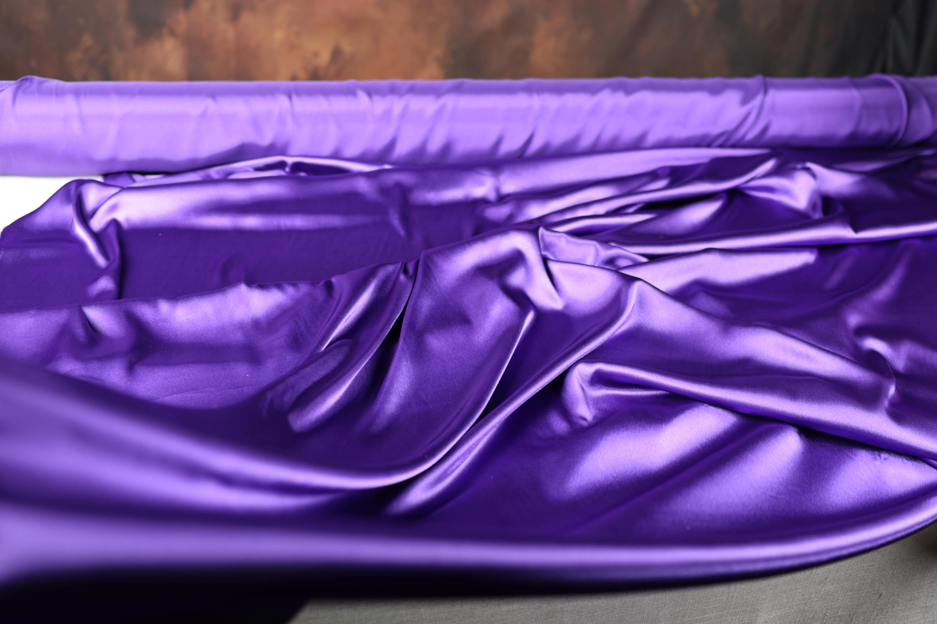 a purple cloth laying on top of a bed