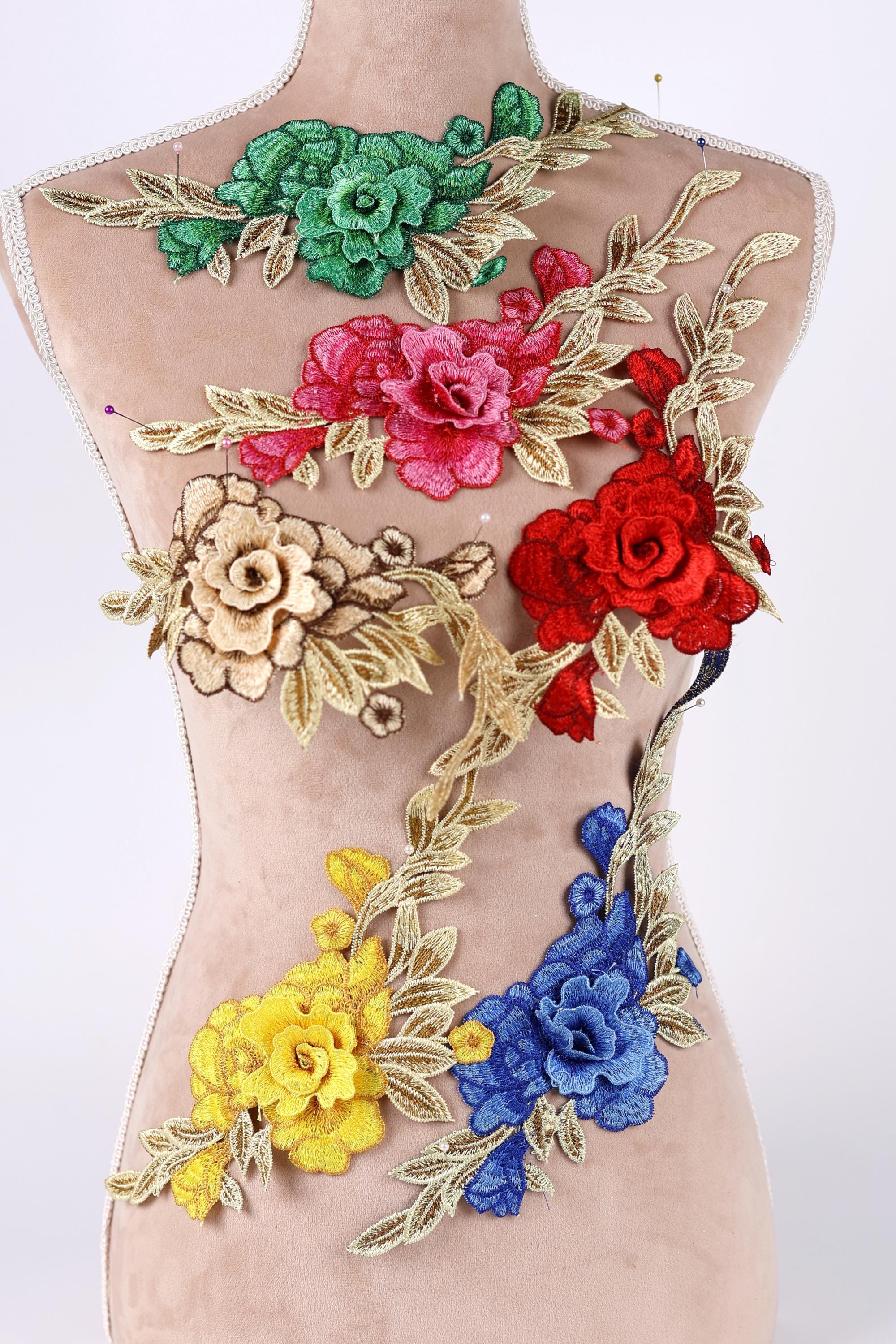 A mannequin torso with colorful floral embroidery patches on it.