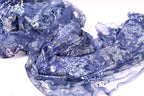 a close-up view of a piece of blue fabric with a floral pattern, featuring a mix of blue and white colors.