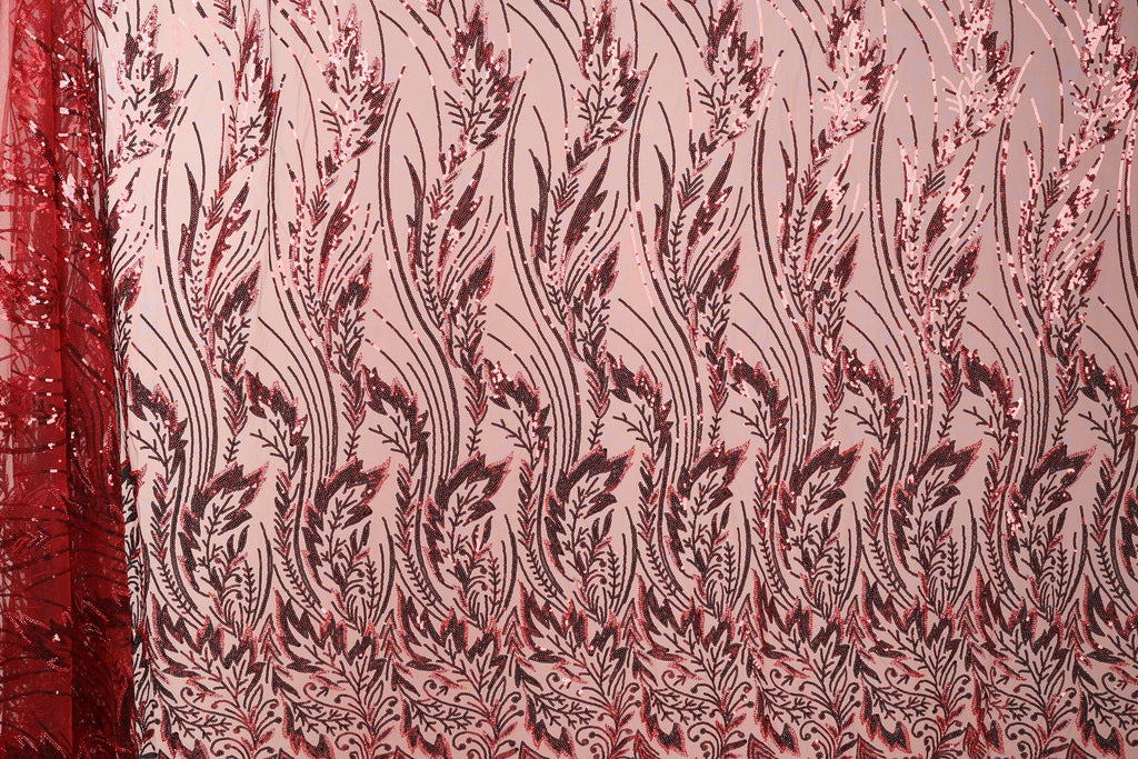 a close-up view of a fabric with a repeating pattern of red and black floral designs. The pattern is intricate and detailed, with the flowers and leaves appearing in various sizes and orientations. The fabric appears to be made of a material with a metallic or sequined texture, adding a touch of sparkle and shine to the overall design.