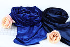 a close-up view of two fabric swatches, one blue and one black, with delicate pink roses resting on top of them.