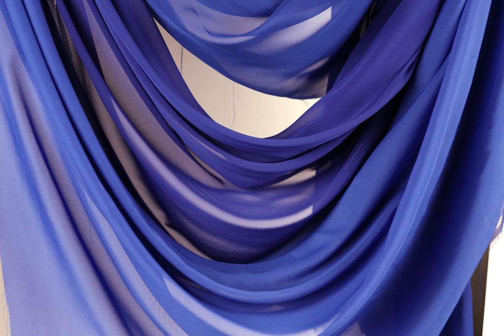 a close-up view of a blue fabric, possibly a chiffon or sheer material, with a textured and flowing appearance.