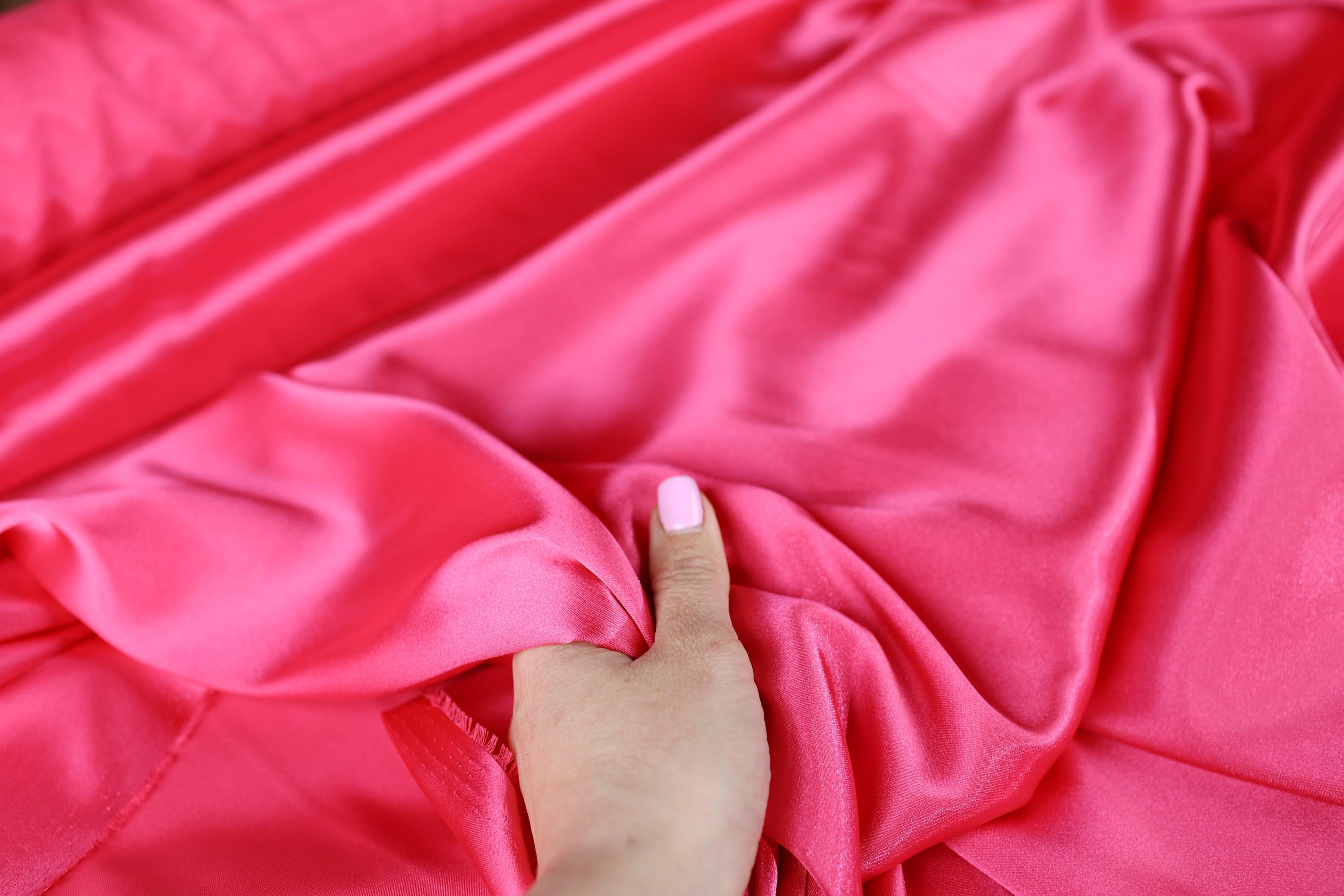 a woman's hand on a pink cloth