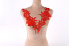 A mannequin wearing a red lace necktie with intricate floral patterns.