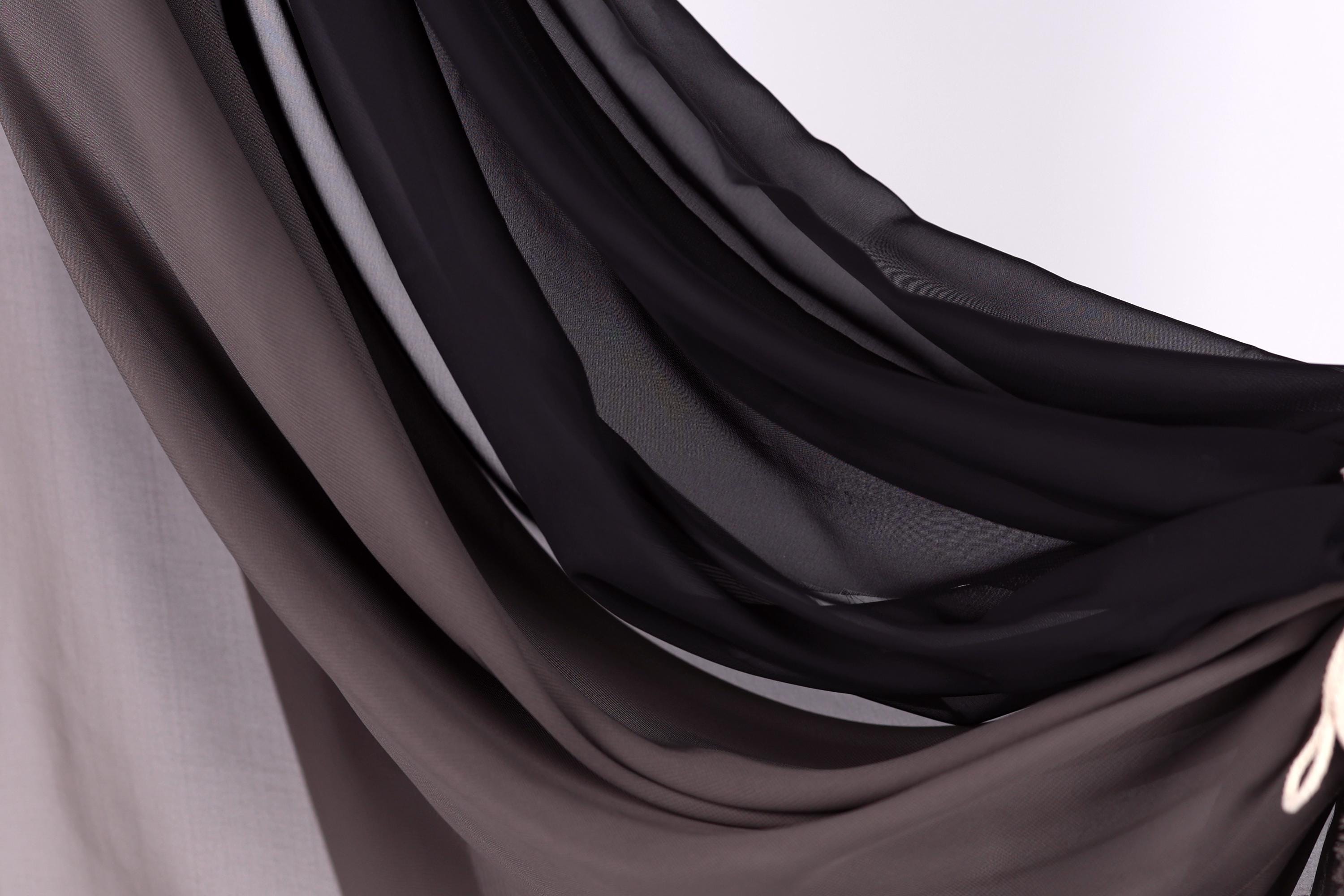 a close-up view of a fabric with a mix of black and gray colors, creating a textured and layered appearance.