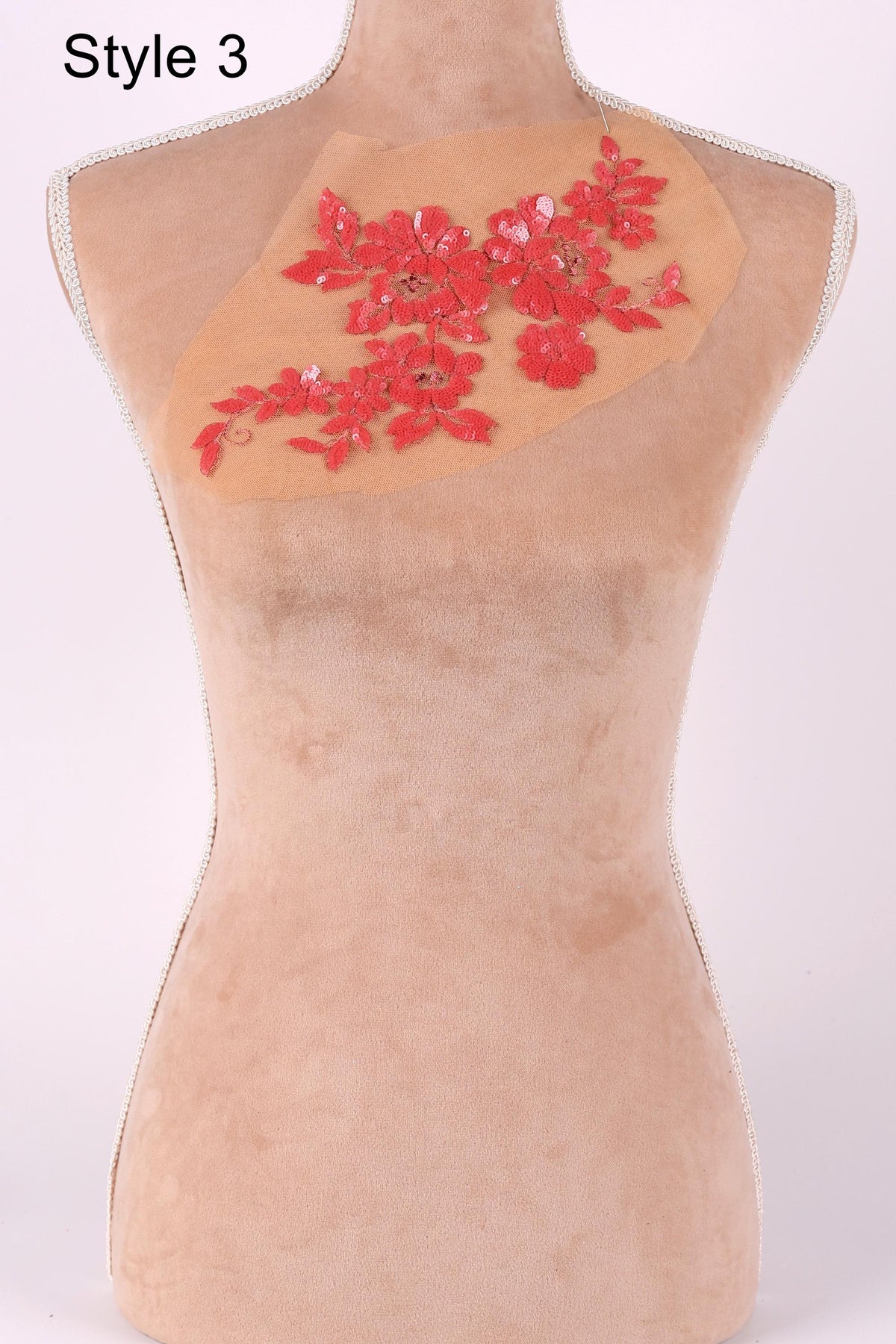 A mannequin with a red floral embroidered patch on its chest.