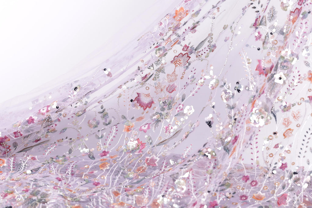 The image is a close-up view of a fabric with a floral pattern, featuring a variety of colorful flowers and leaves.