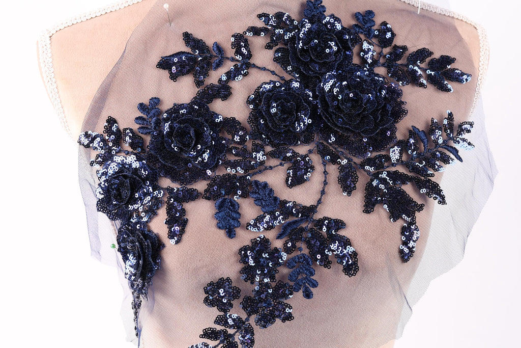 A mannequin torso with a decorative floral embroidery on the back.