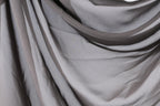 a close-up view of a gray fabric, possibly a sheer or sheer-like material, with a slightly wrinkled texture.