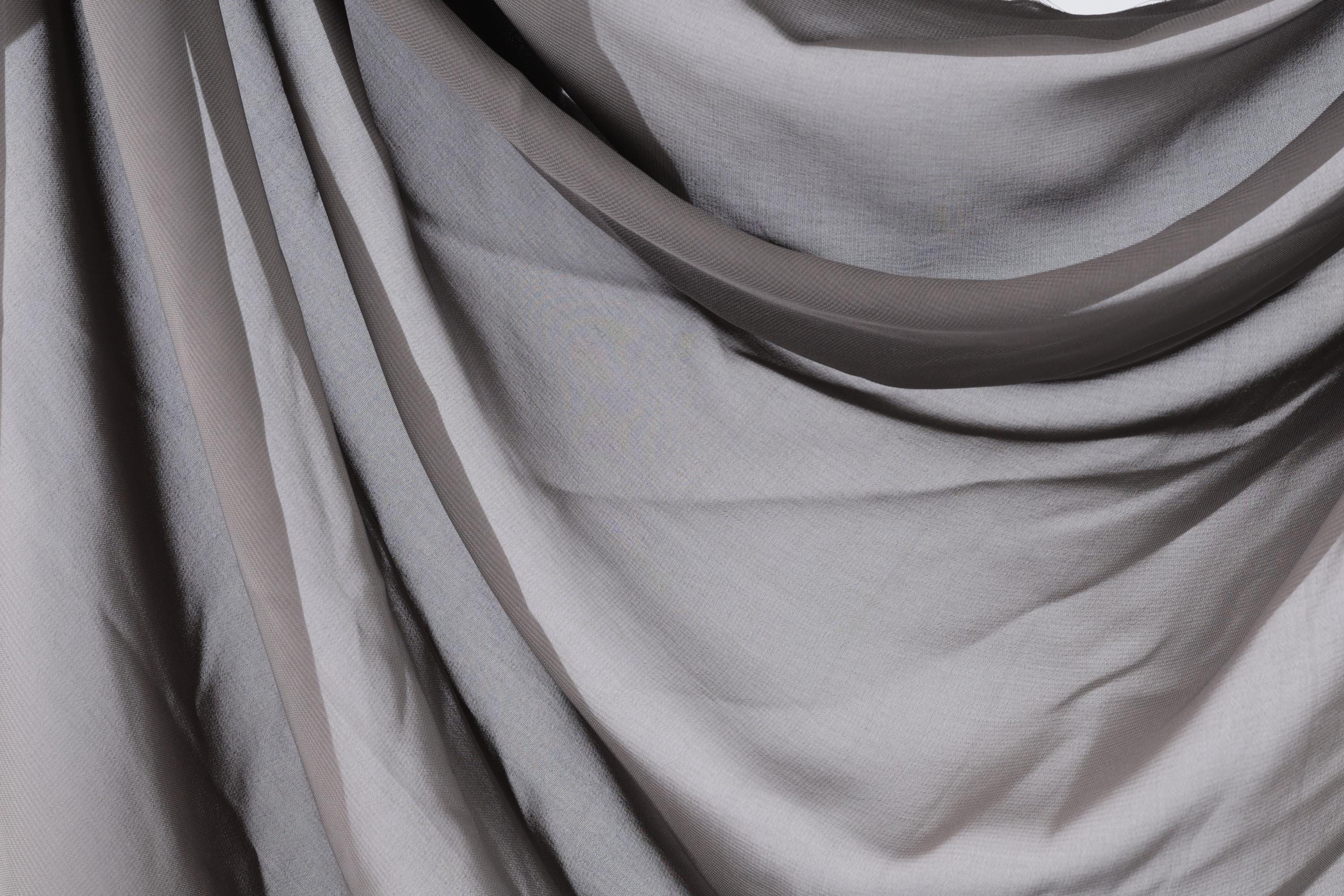 a close-up view of a gray fabric, possibly a sheer or sheer-like material, with a slightly wrinkled texture.