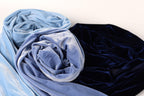 two pieces of fabric, one blue and one black, with a close-up view of the fabric's texture and folds.