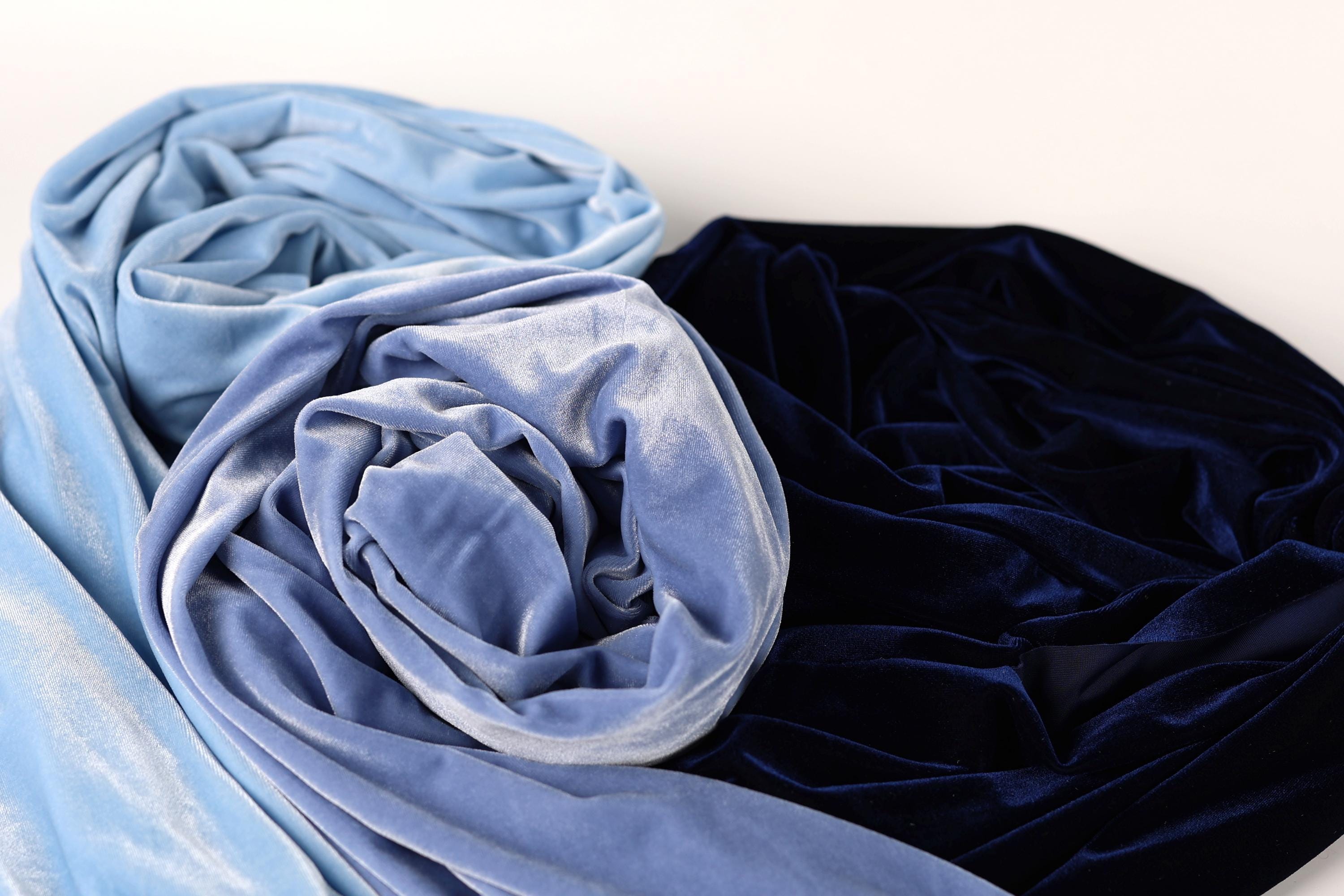 two pieces of fabric, one blue and one black, with a close-up view of the fabric's texture and folds.