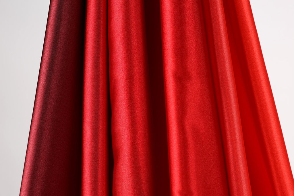 a close-up view of a red and black fabric, with the red fabric appearing more vibrant and the black fabric appearing slightly faded.