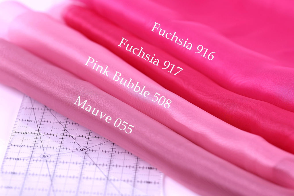 a close-up view of three different shades of pink fabric, with a ruler placed next to them. The text labels the fabric shades as Fuchsia 916, Pink Bubble 518, and Mauve 055.