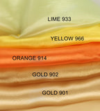 A close-up image of a stack of fabric swatches in various colors, including lime green, yellow, orange, gold, and gold.