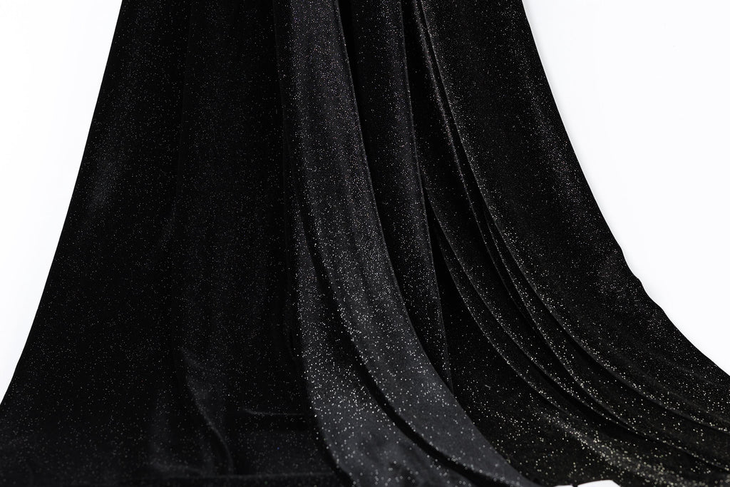 a close-up view of a black velvet fabric with a sparkly texture, creating a shiny and luxurious appearance.
