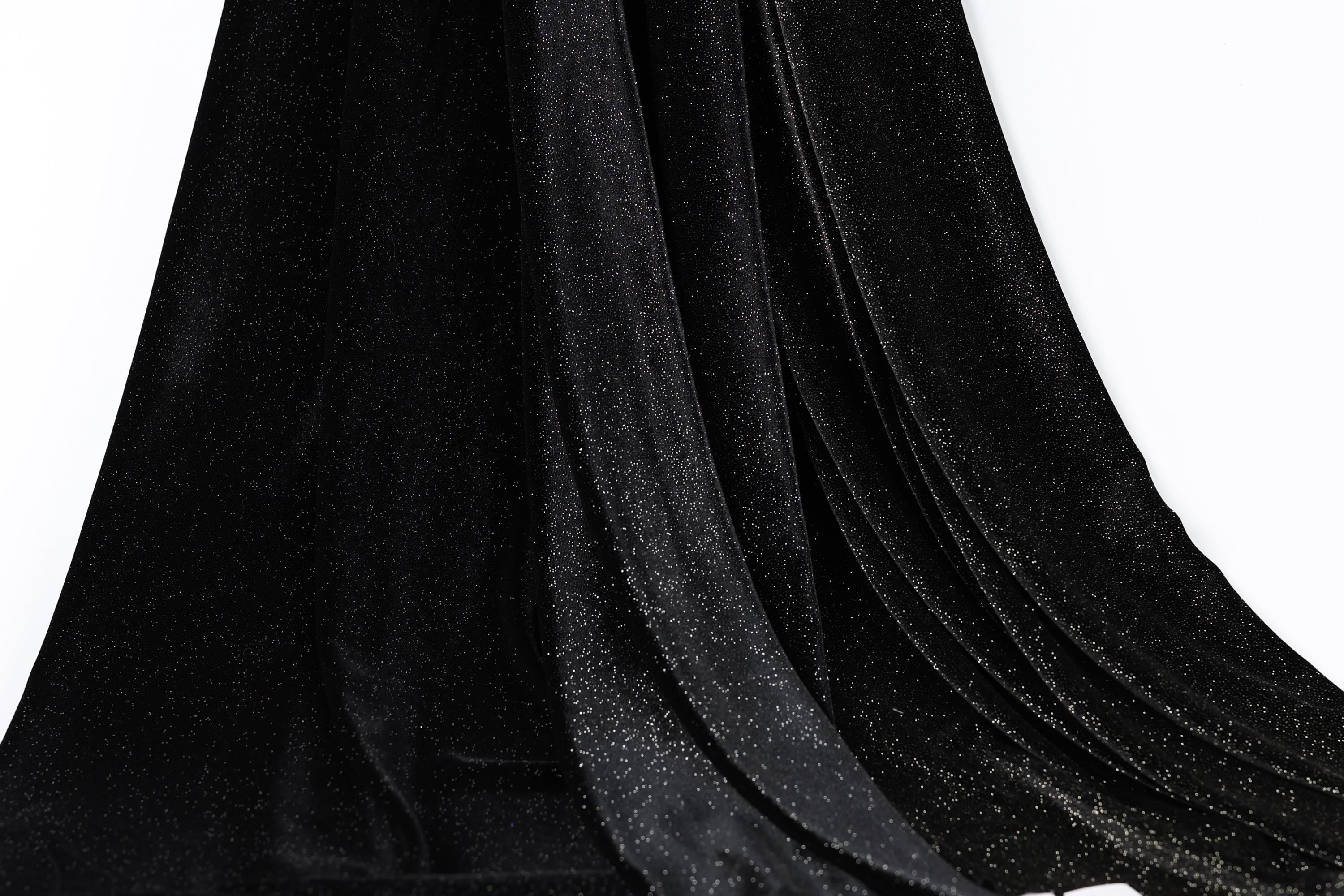 a close-up view of a black velvet fabric with a sparkly texture, creating a shiny and luxurious appearance.