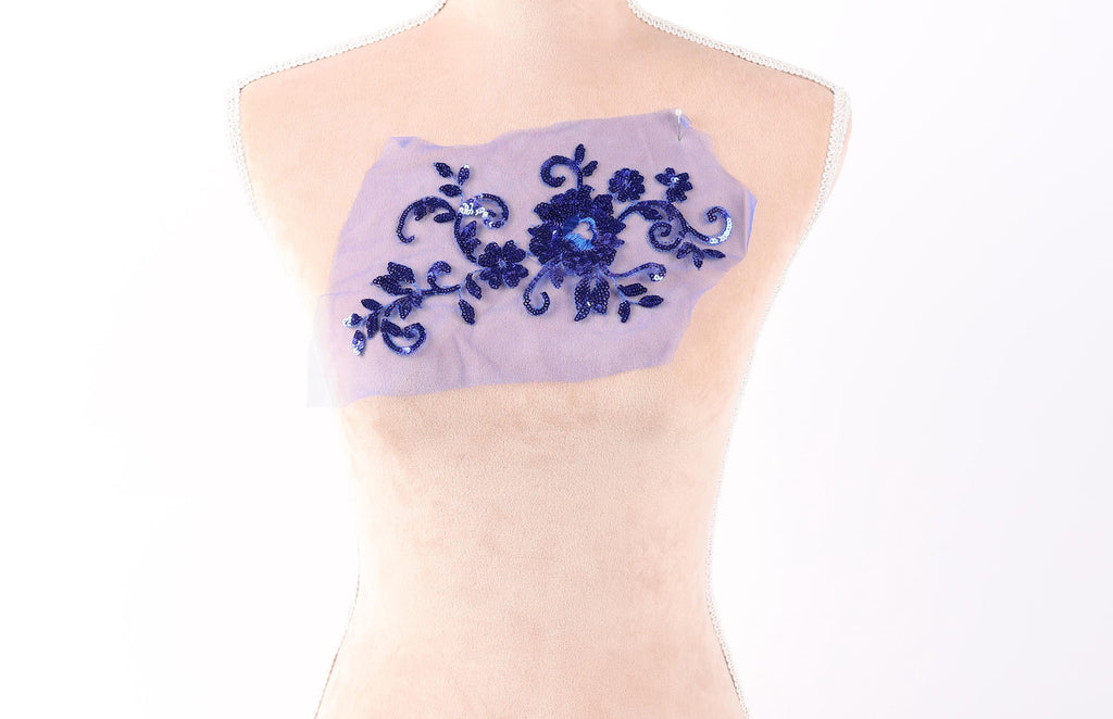 A mannequin torso with a piece of fabric or material attached to it, featuring a floral pattern in blue and purple colors.